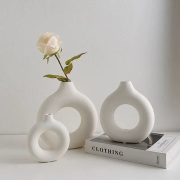 A Circular, Donut-Shaped Plastic Vase For Single Flower Arrangements And Home Decoration.